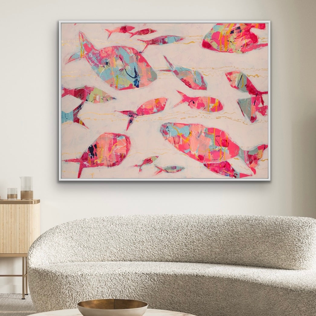 Colorful red abstract fish artwork on a wall above a sofa in a living room.