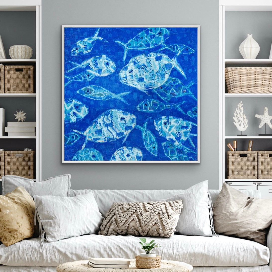 Living room with a blue abstract fish giclée canvas print on the wall, white sofa, and decorative pillows.