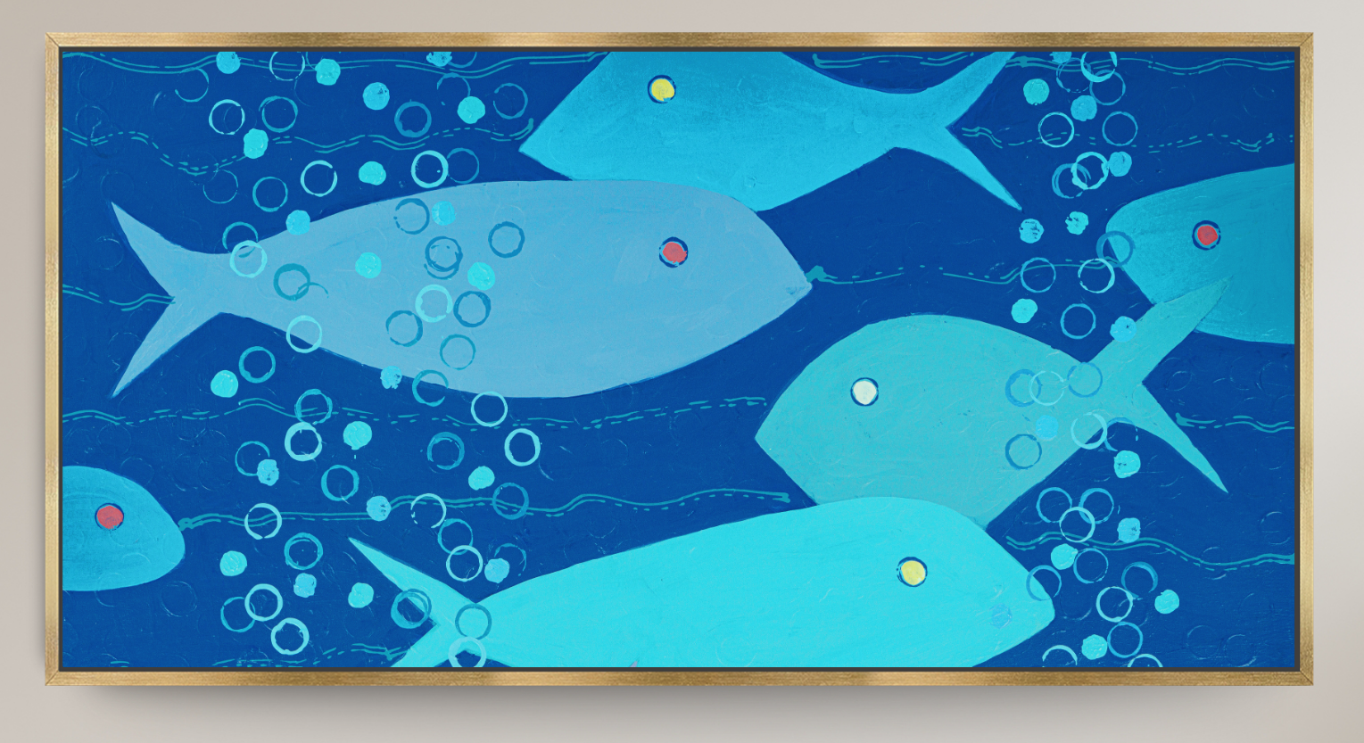 A framed square art print depicting stylized light blue fish swimming in a deep blue underwater scene with white bubbles, set against a light beige wall.