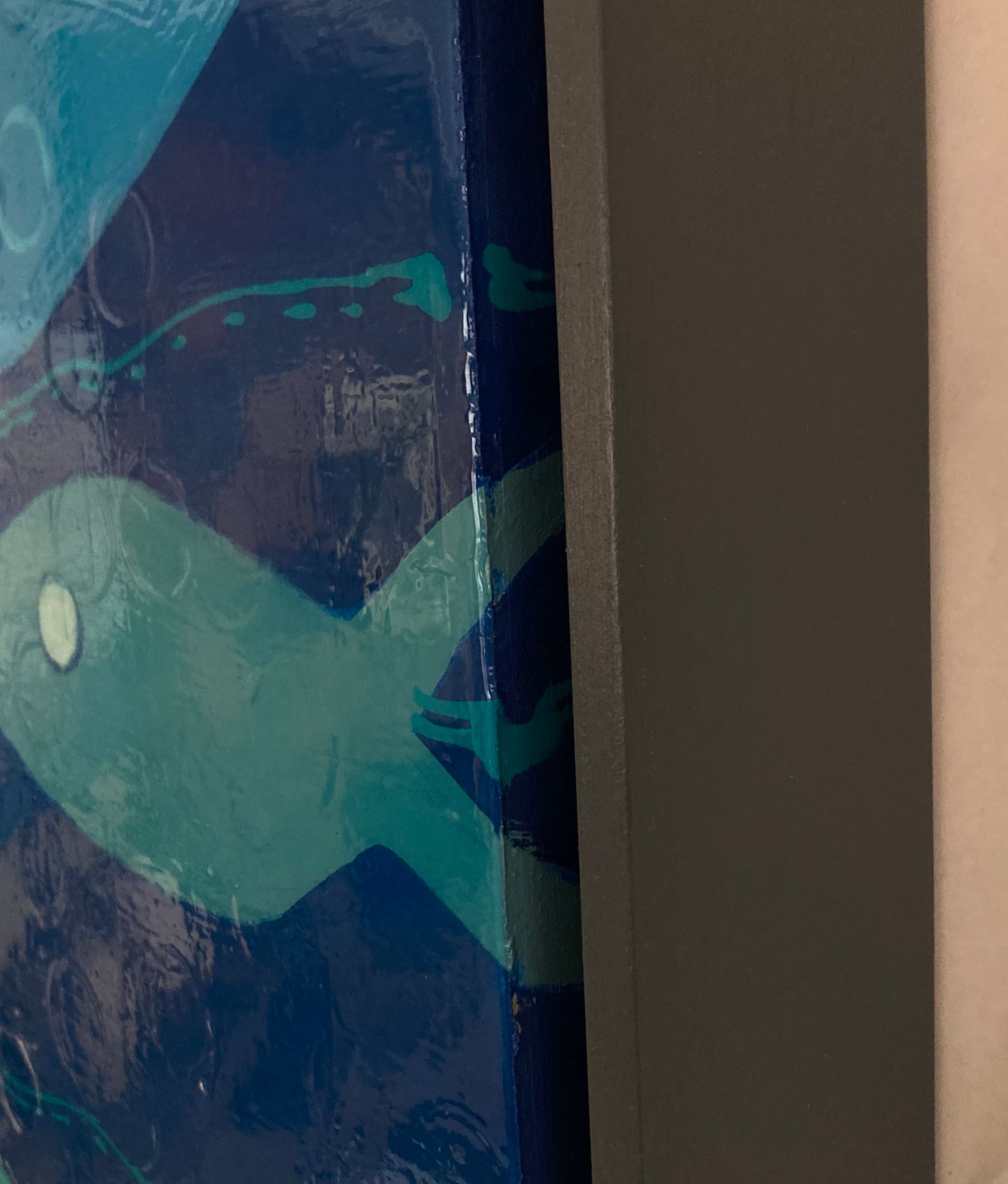 Close-up detail of acrylic pour texture and layered blue surface in frame of Bubbles in Blue.
