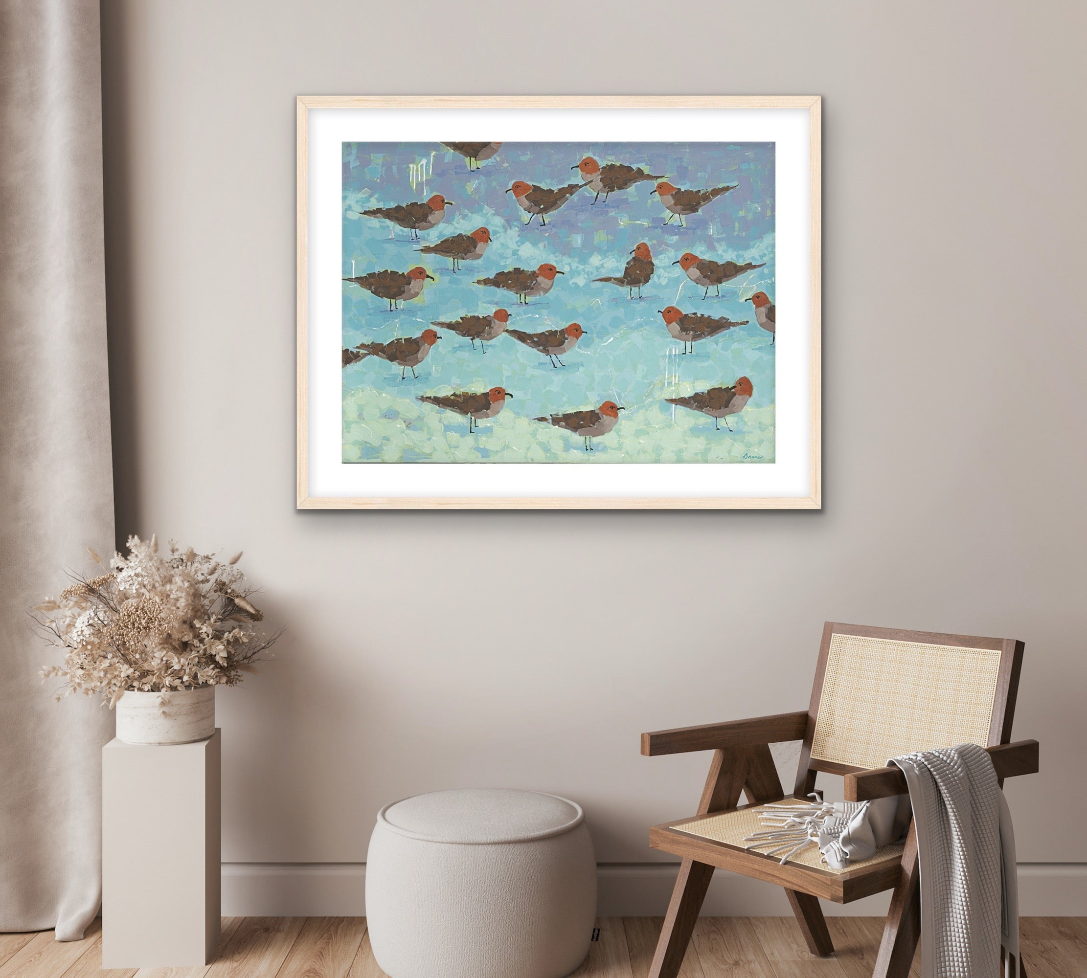 Morning Briefing II by Martha Brane – coastal fine art print featuring sandpipers along aqua and seafoam waters in a room with a chair and plant.