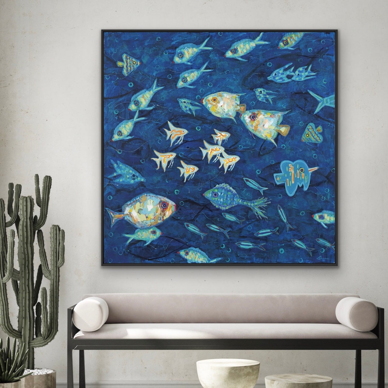 Framed artwork of abstract ocean fish on a blue background in a living room setting.