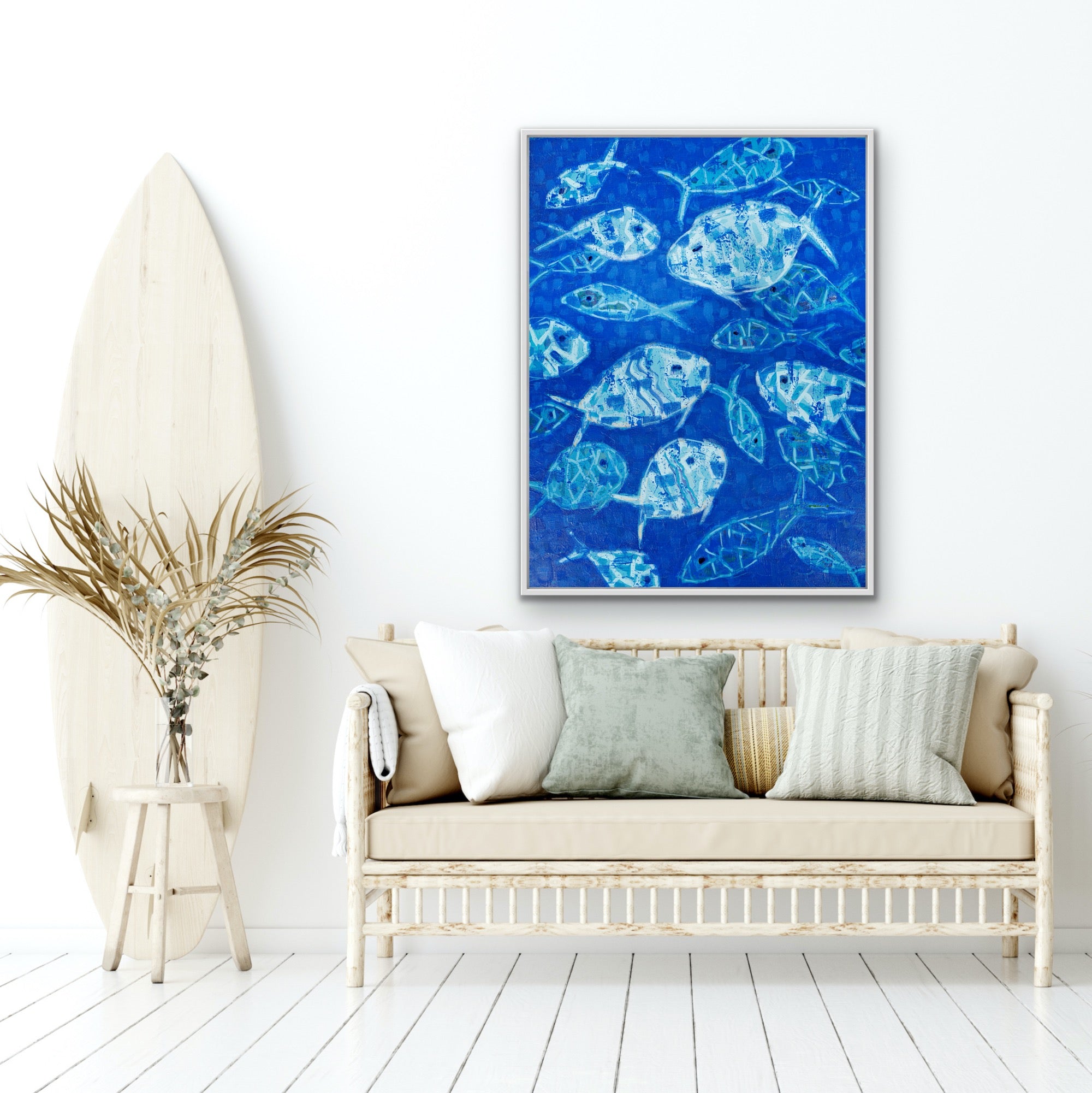 Living room with a blue coastl luxury abstract fish artwork on the wall, a white couch, and a surfboard.