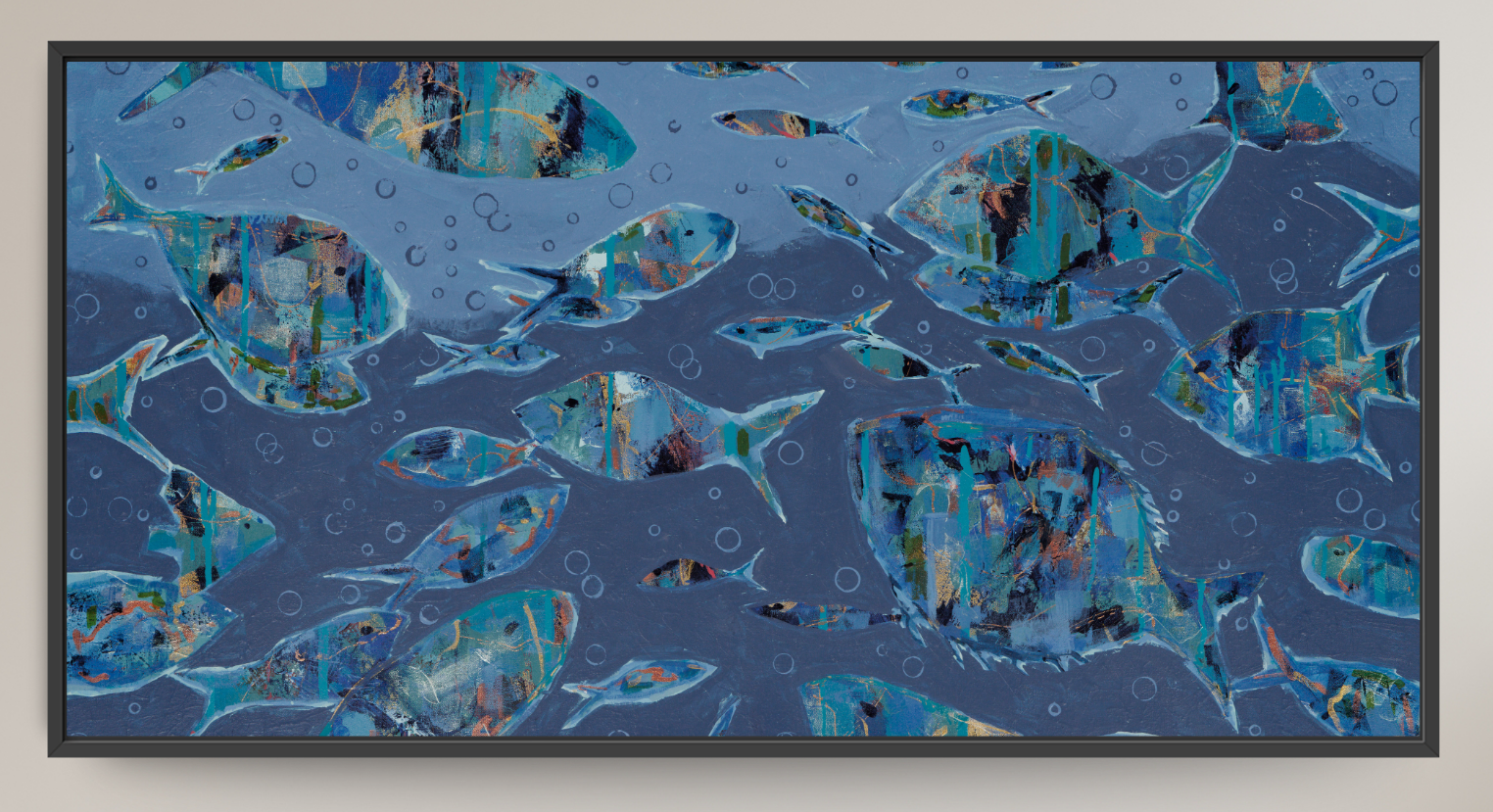 A framed abstract art print depicting school of fish swimming underwater, rendered in shades of blue, teal, and gray with textured brushstrokes and bubble details, set against a light beige wall.