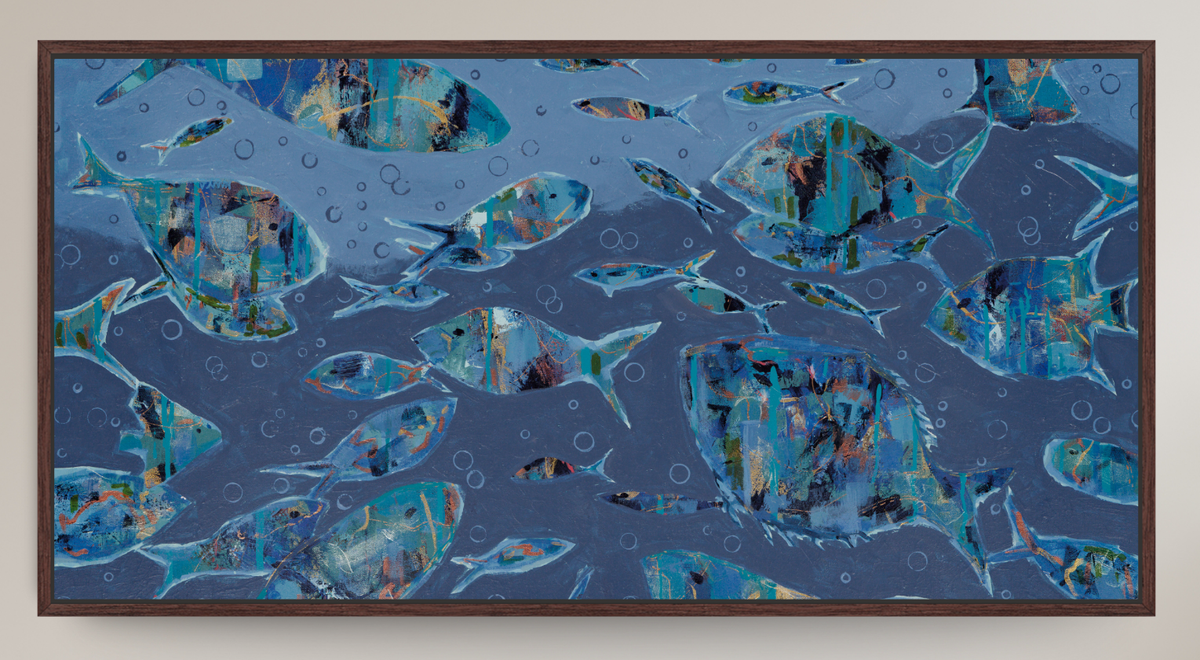 Framed square wall art featuring an abstract underwater scene with many blue fish swimming over a textured blue background, shown against a light neutral wall.