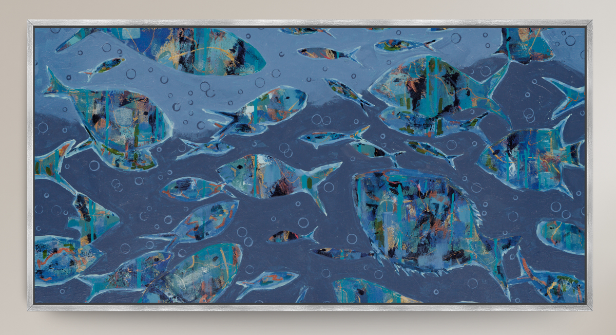 An abstract framed wall art piece depicting a school of fish swimming underwater, rendered in textured shades of blue, teal, and navy with small bubble details, set against a light beige wall.