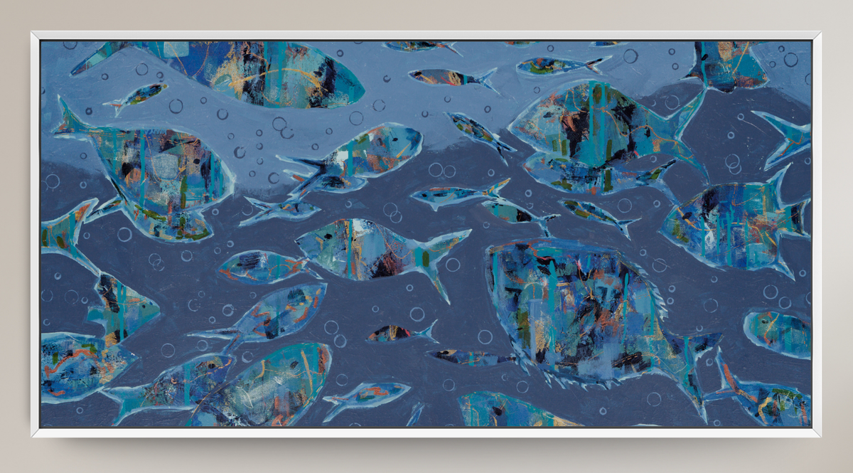 Framed abstract art print depicting a school of fish swimming underwater in shades of blue, teal, and gray, with a white frame and a light beige wall background.