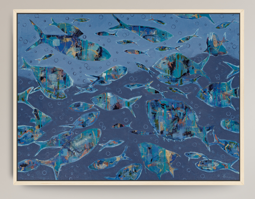 An abstract framed art print depicting a school of fish swimming underwater in shades of blue, teal, and gold, set in a light wood frame against a neutral gray background.