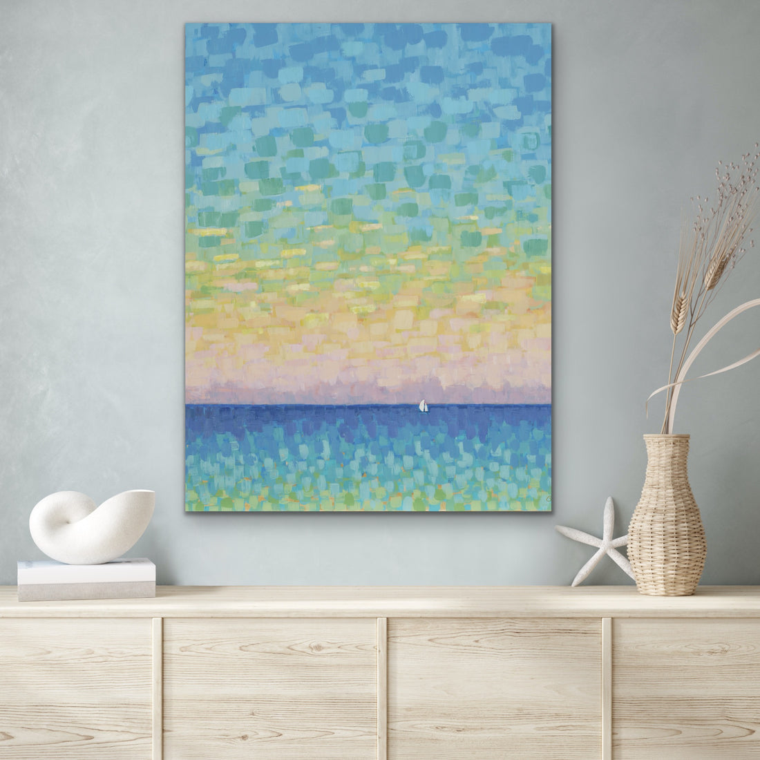 Abstract  sunset ocean landscape painting on a wall above a wooden cabinet with decorative items.