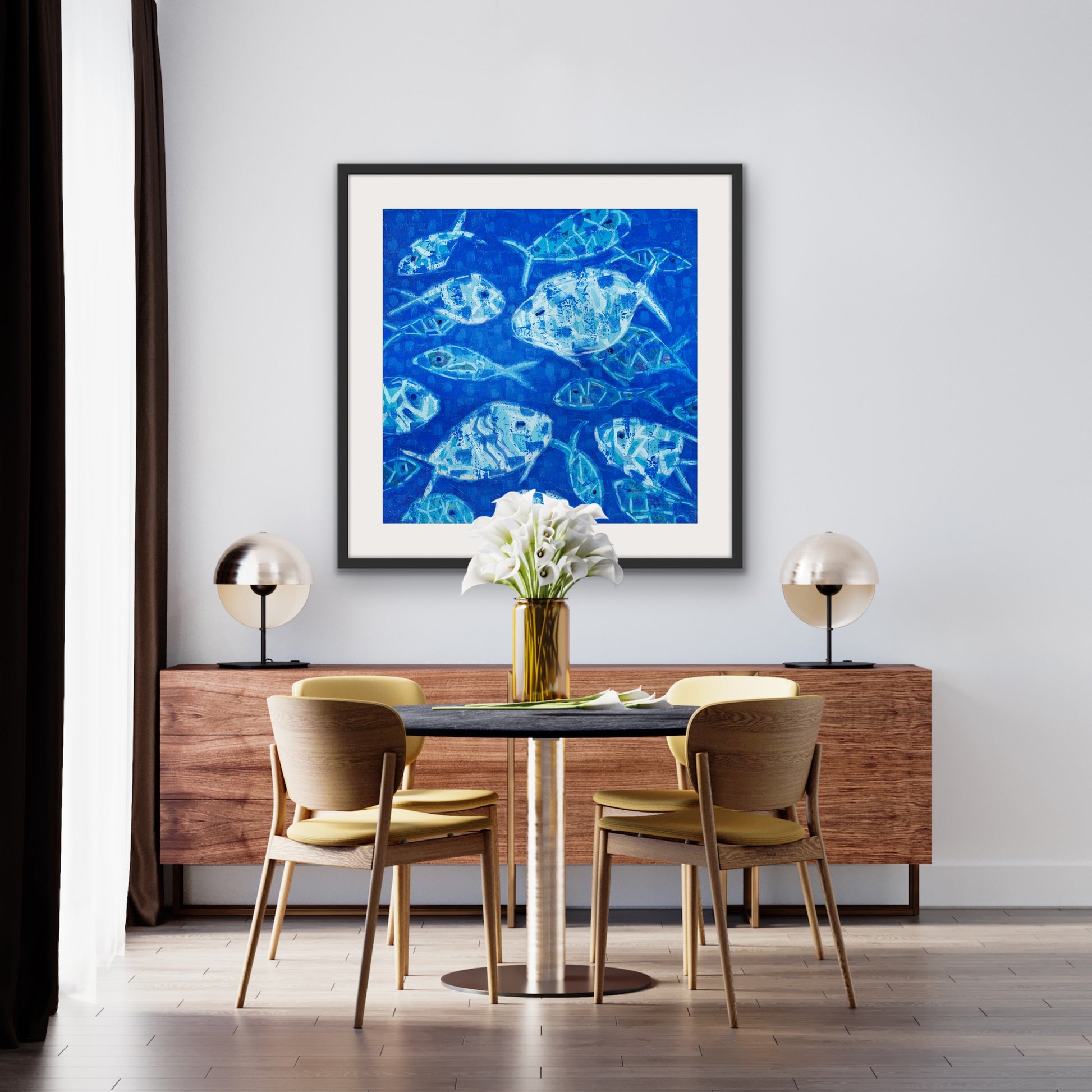 Dining room with a luxury cotton rag giclée of blue fish composition on the wall, wooden table, and chairs.