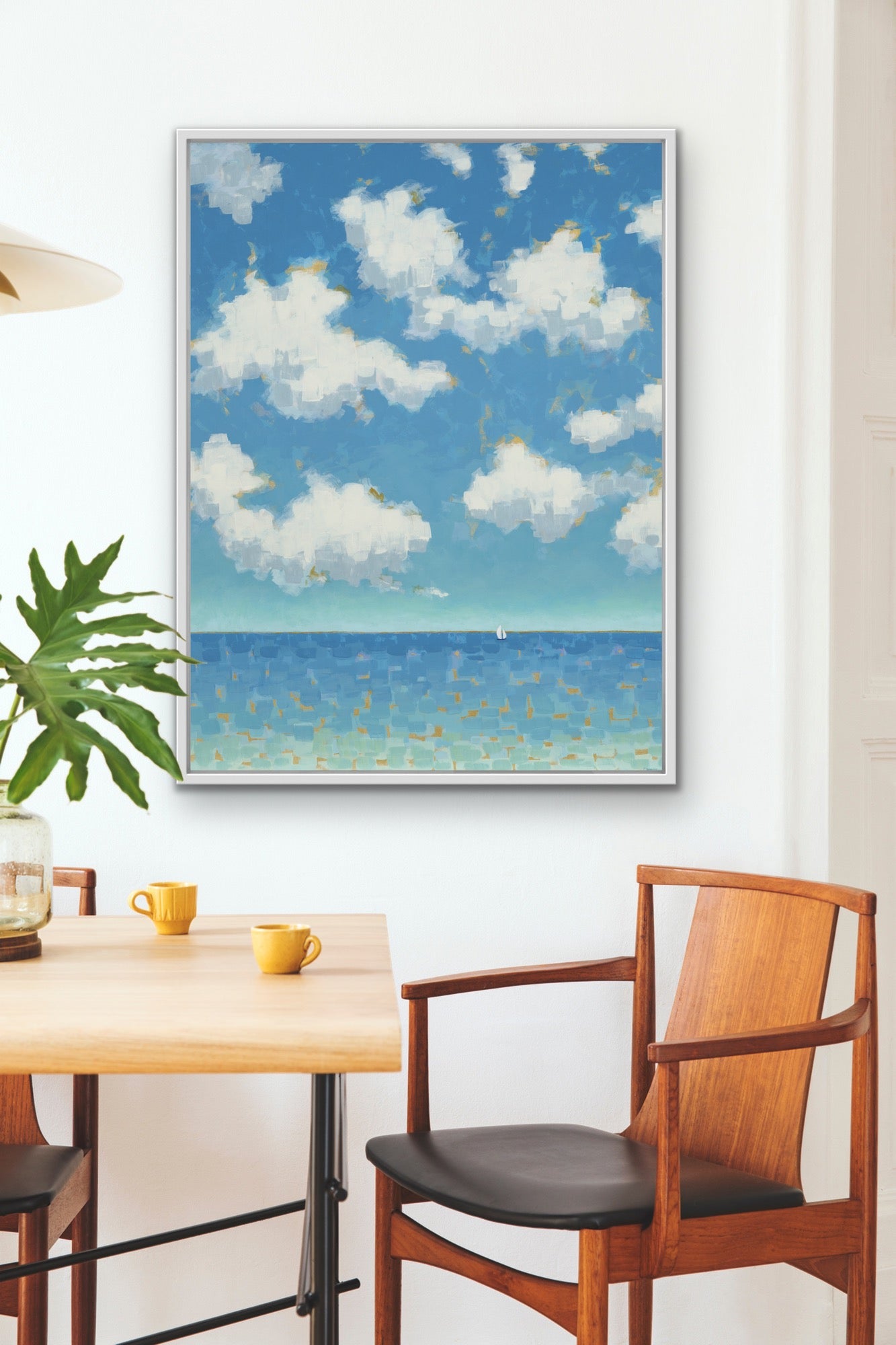 Luxury giclée canvas print in soft blues and turquoise tones framed artwork on a wall above a dining table and chairs.