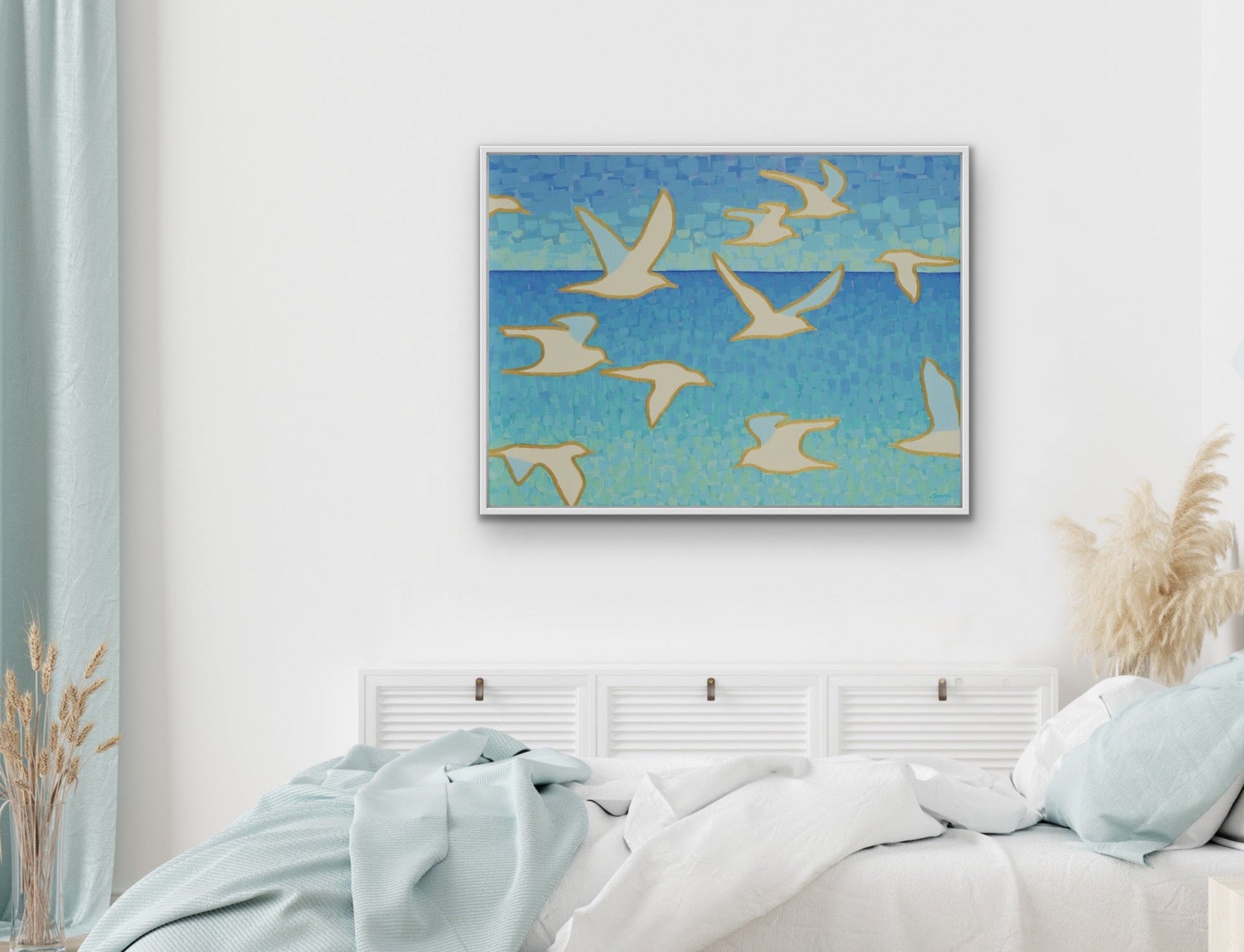 Blue and teal seascape with abstract white birds symbolizing freedom and light, giclée print by Martha Brane on the wall in a bedroom. 