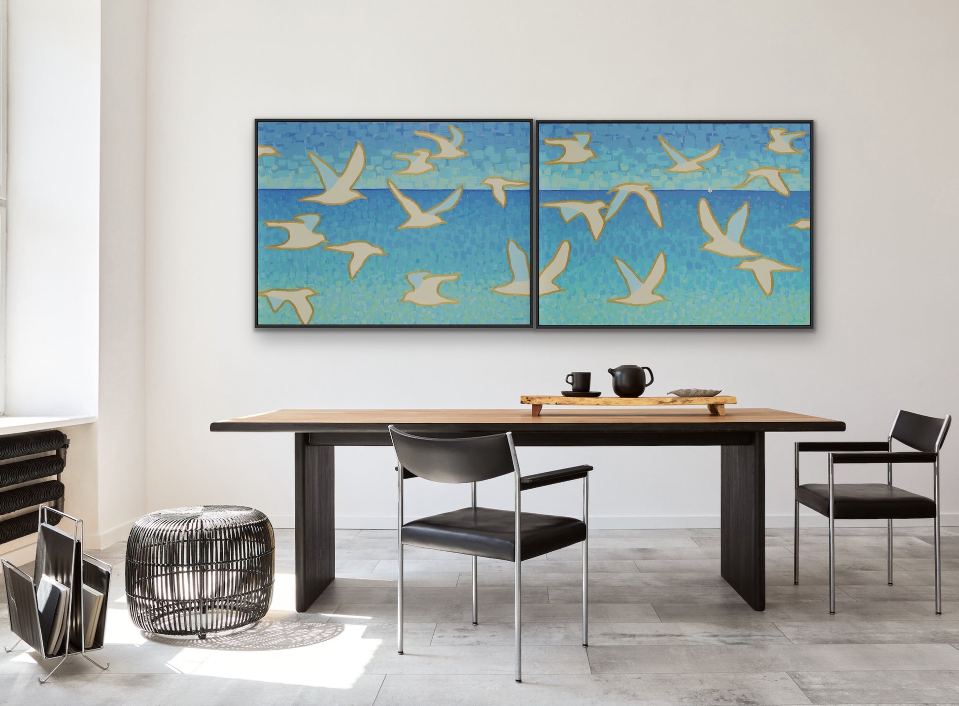 Wings of Light I and II modern coastal fine art prints on canvas, featuring white birds and distant sailboat in a dining room with a large table and chairs.  