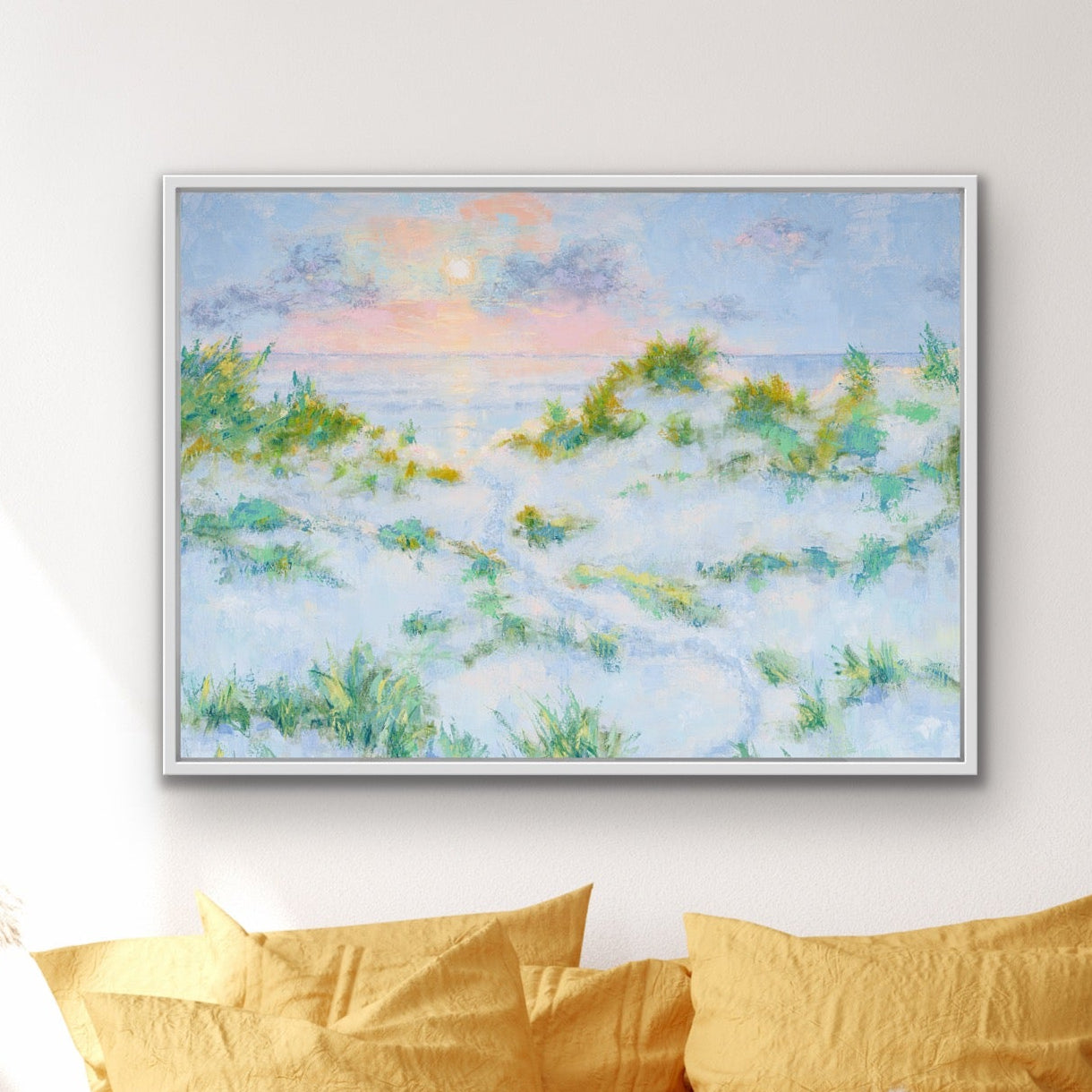Yellow bed with pillows and a painting of a Summer Dreams horizontal edition framed landscape beach scene on the wall.