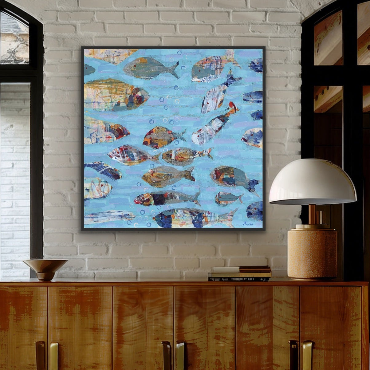 Wooden sideboard with a large coastal canvas print showing fish swimming through textured blue waters on a white brick wall.