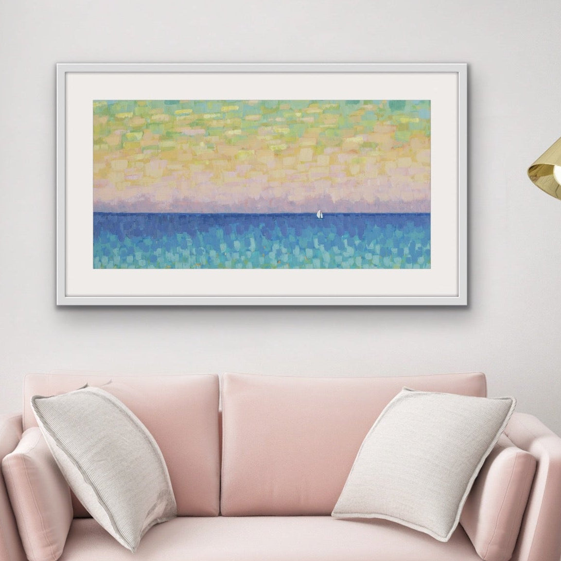 Pink sofa with a colorful abstract coastal sunset painting on the wall in a living room setting.