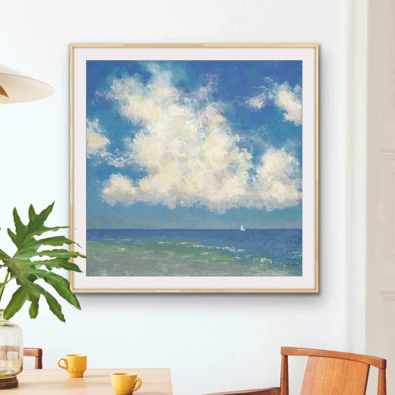 Luminous Cloud Filled Ocean Scene with Sailboat on the wall with table and chairs