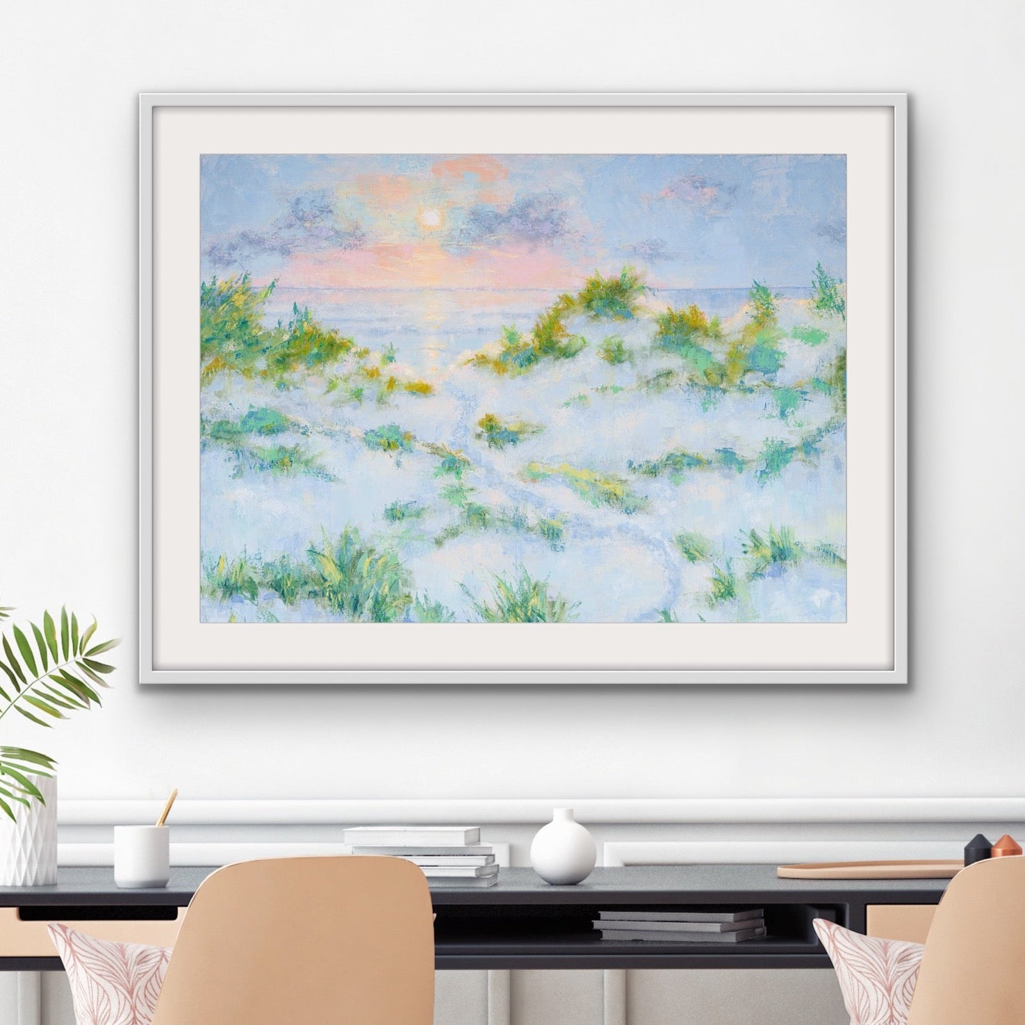Matted and framed beach sunrise artwork in pastel tonesFramed above a desk with chairs in a room setting