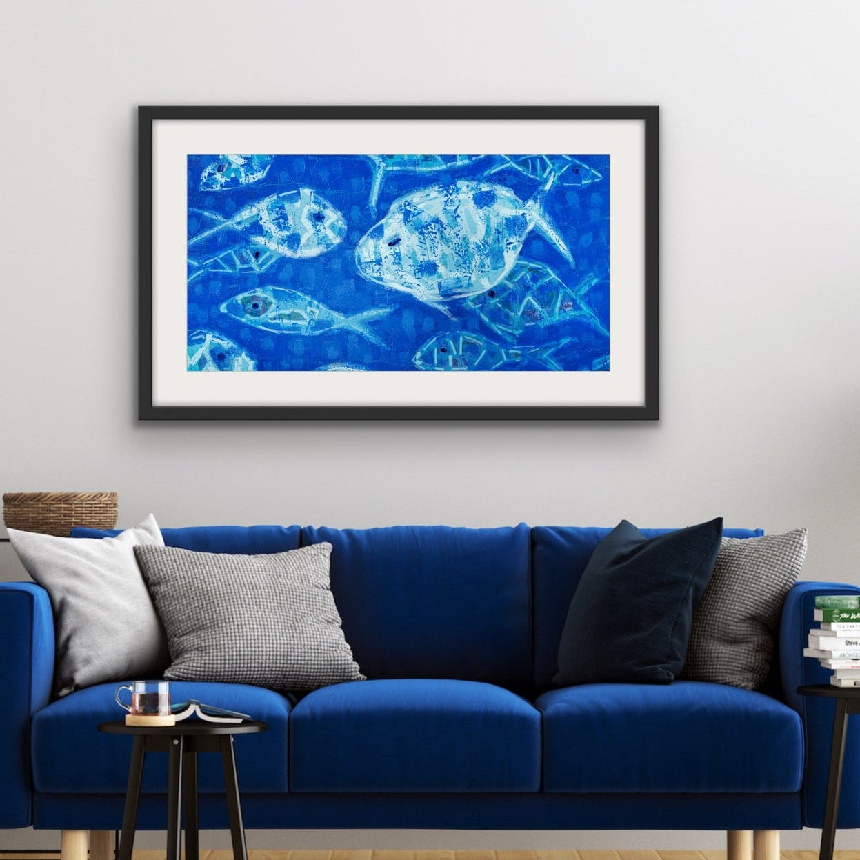 Living room with a blue sofa, museum-quality cotton rag print of abstract swimming fish in blue hues on the wall, and a plant.