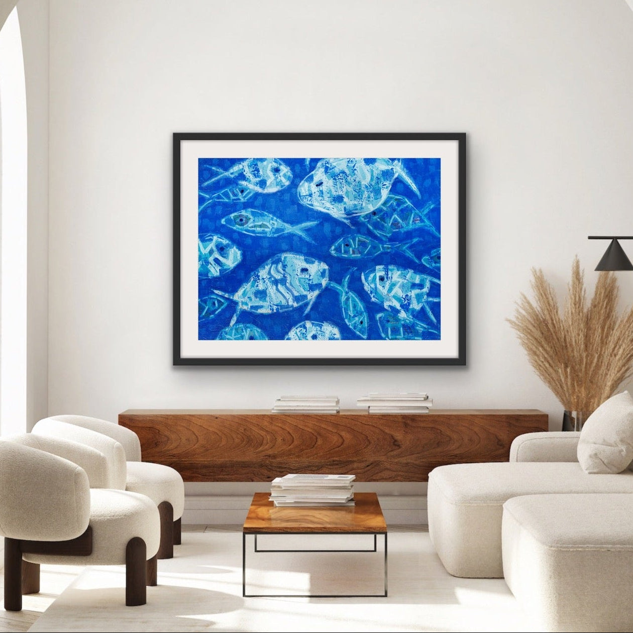 Modern living room with a contemporary blue abstract coastal fish painting on a white wall.