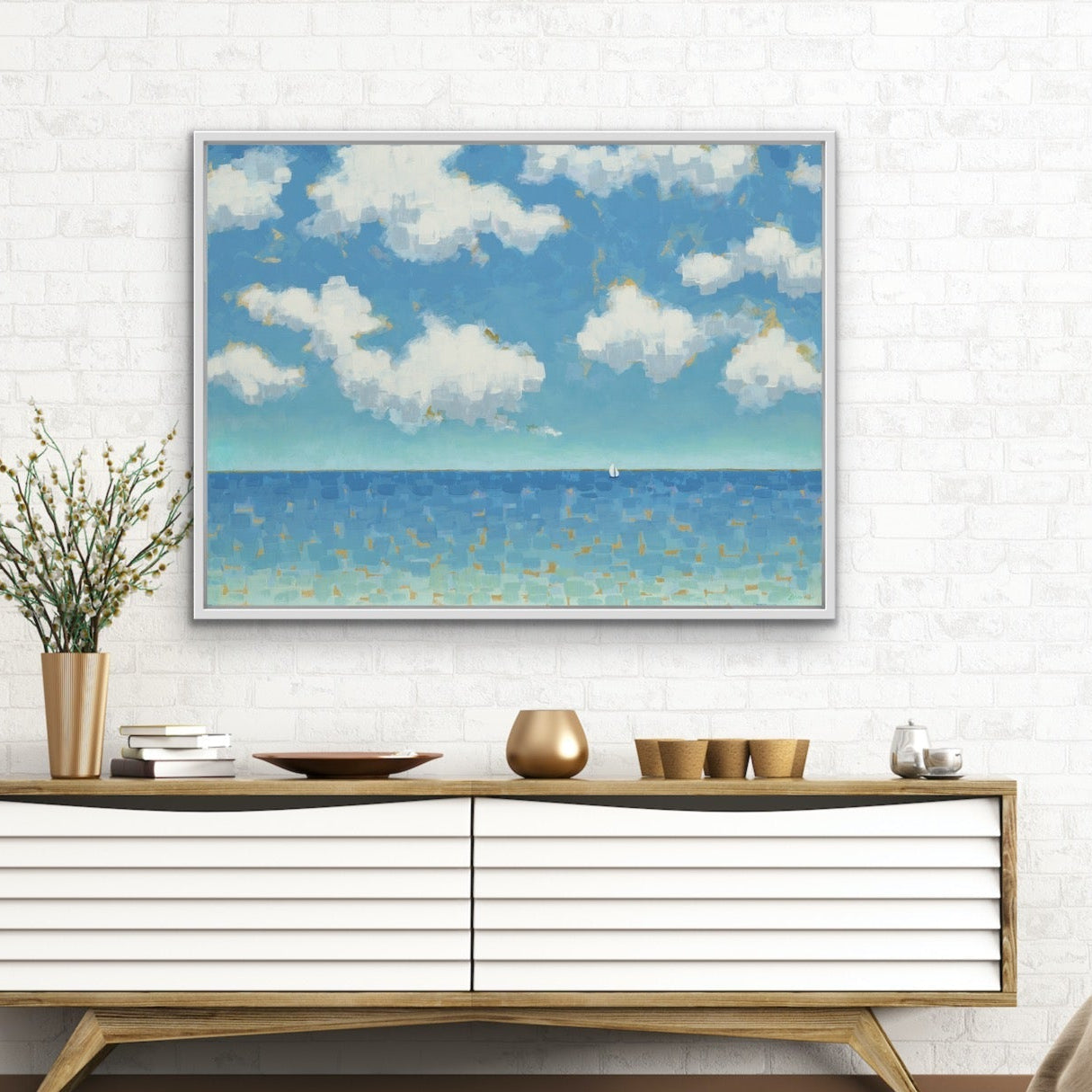 Modern interior with a console table, decorative items, and a large framed  Far and Free seascape artwork featuring soft blue sky and ocean gradient artwork on the wall