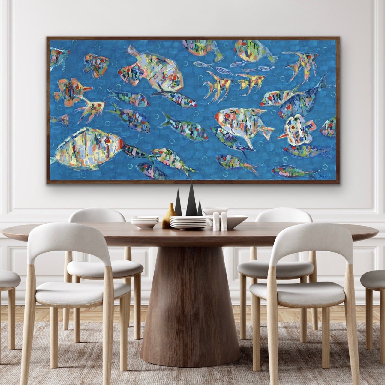 Dining room with a round wooden table and chairs, and a colorful abstract ocean fish painting on the wall.
