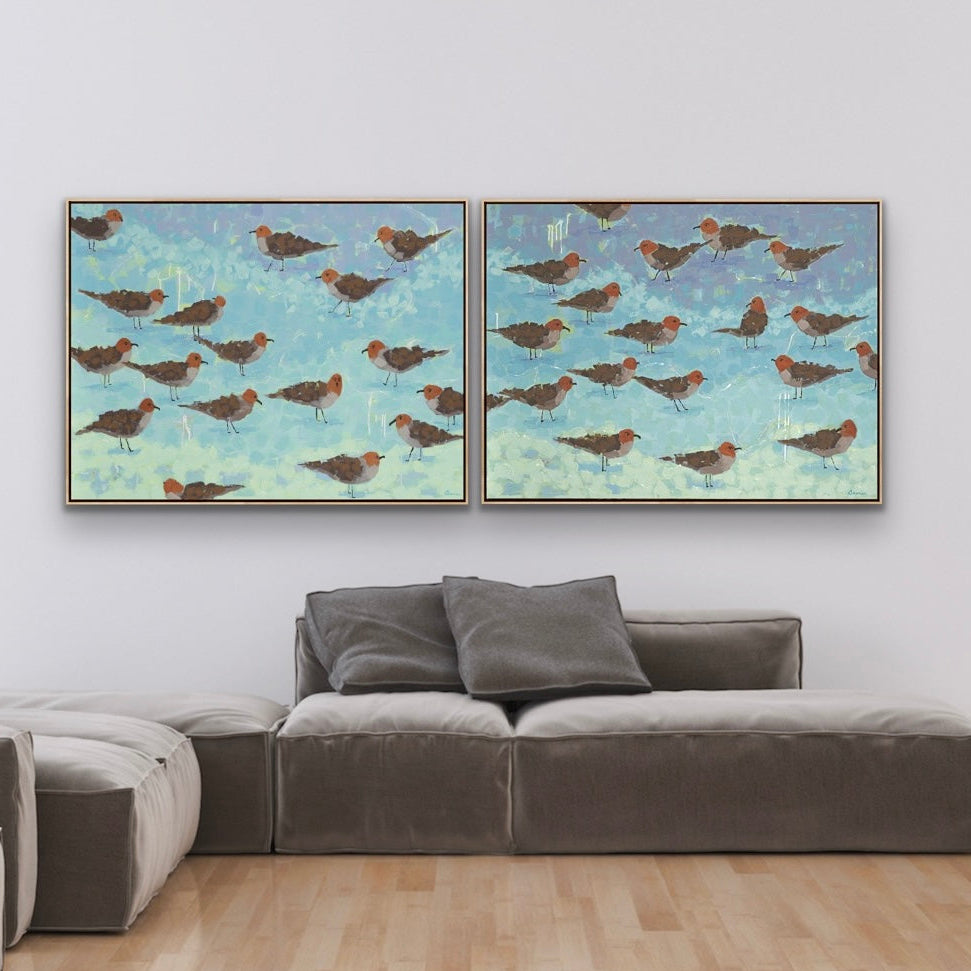 Modern living room with a sectional sofa and Morning Briefing I and II diptych featuring soft blue coastal tones and light-filled color harmony framed artworks on the wall.