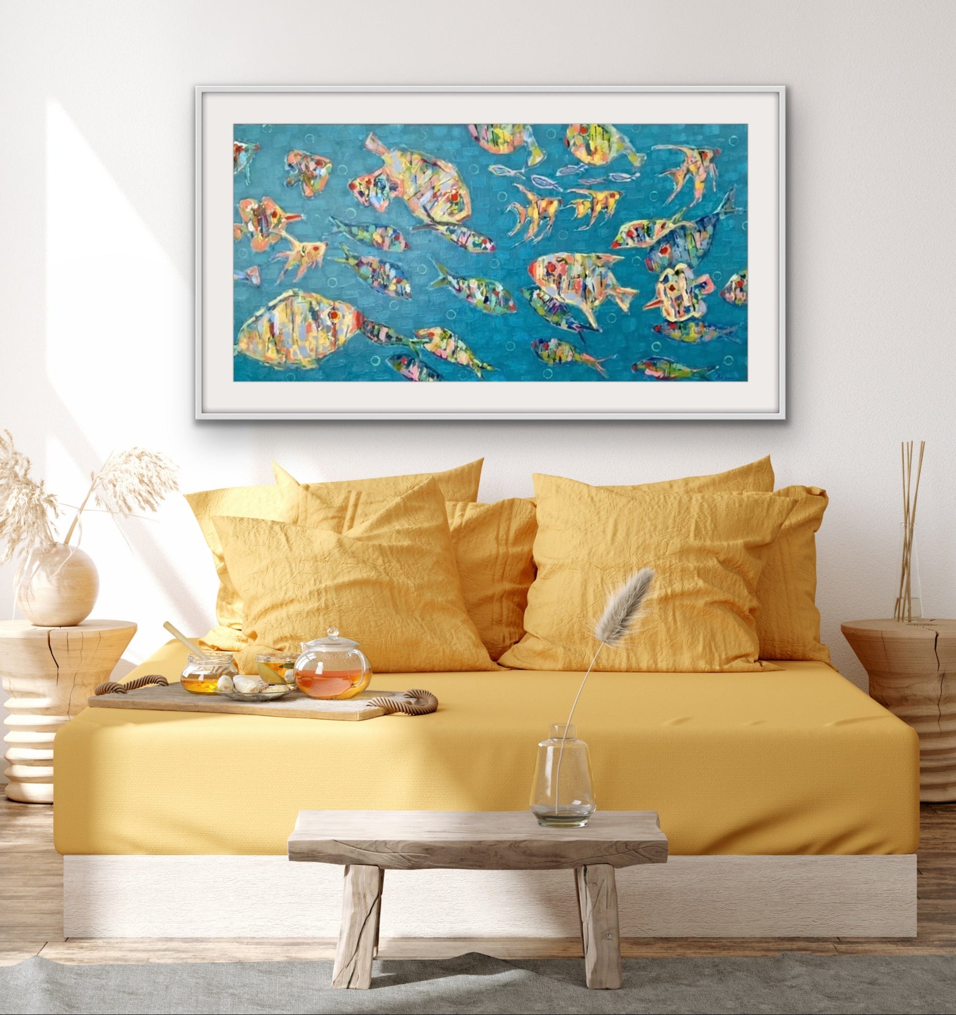 Colorful abstract fish framed on a wall above a yellow bed.