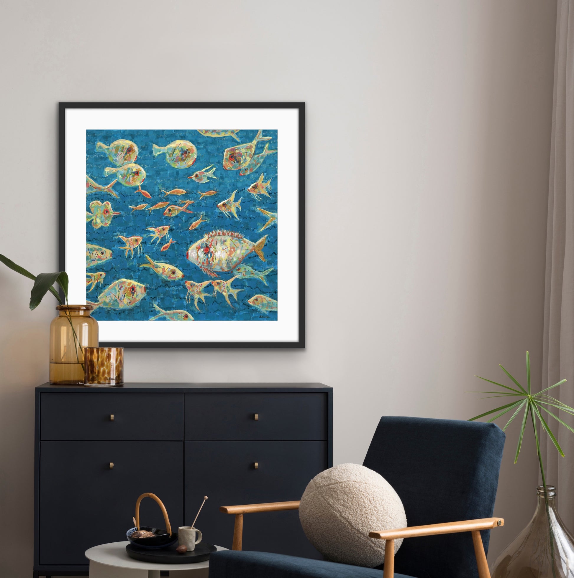 Framed large statement artwork of colorful fish on a blue background in a living room setting.