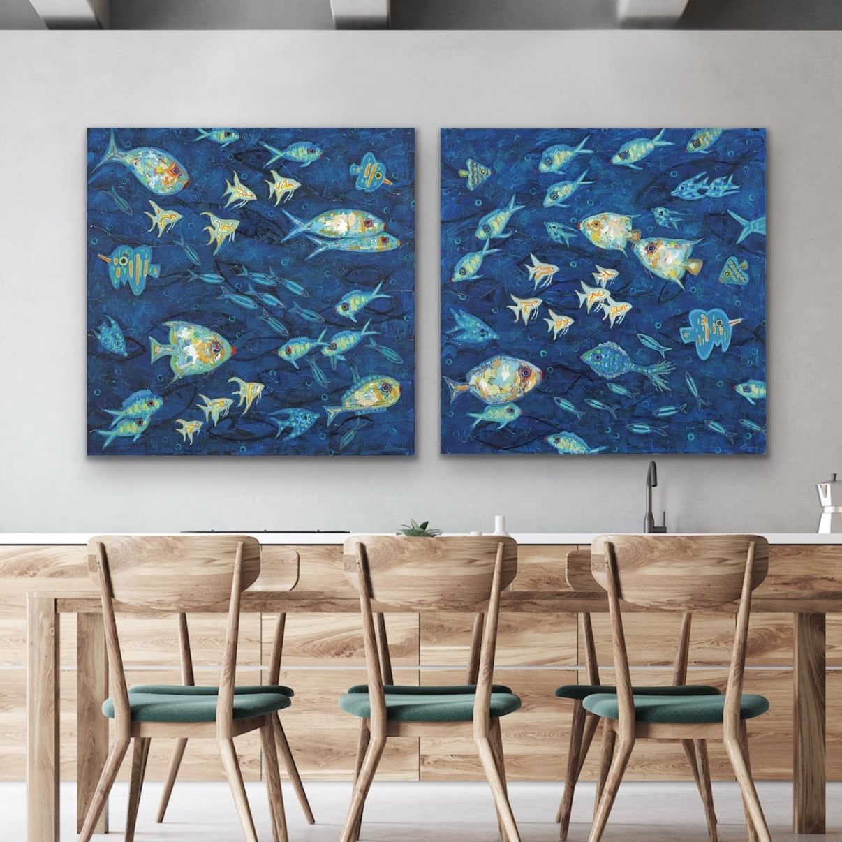 Ocean Gala I & II diptych featuring vibrant coastal fish in deep indigo blueson a Dining room with wooden table and chairs.