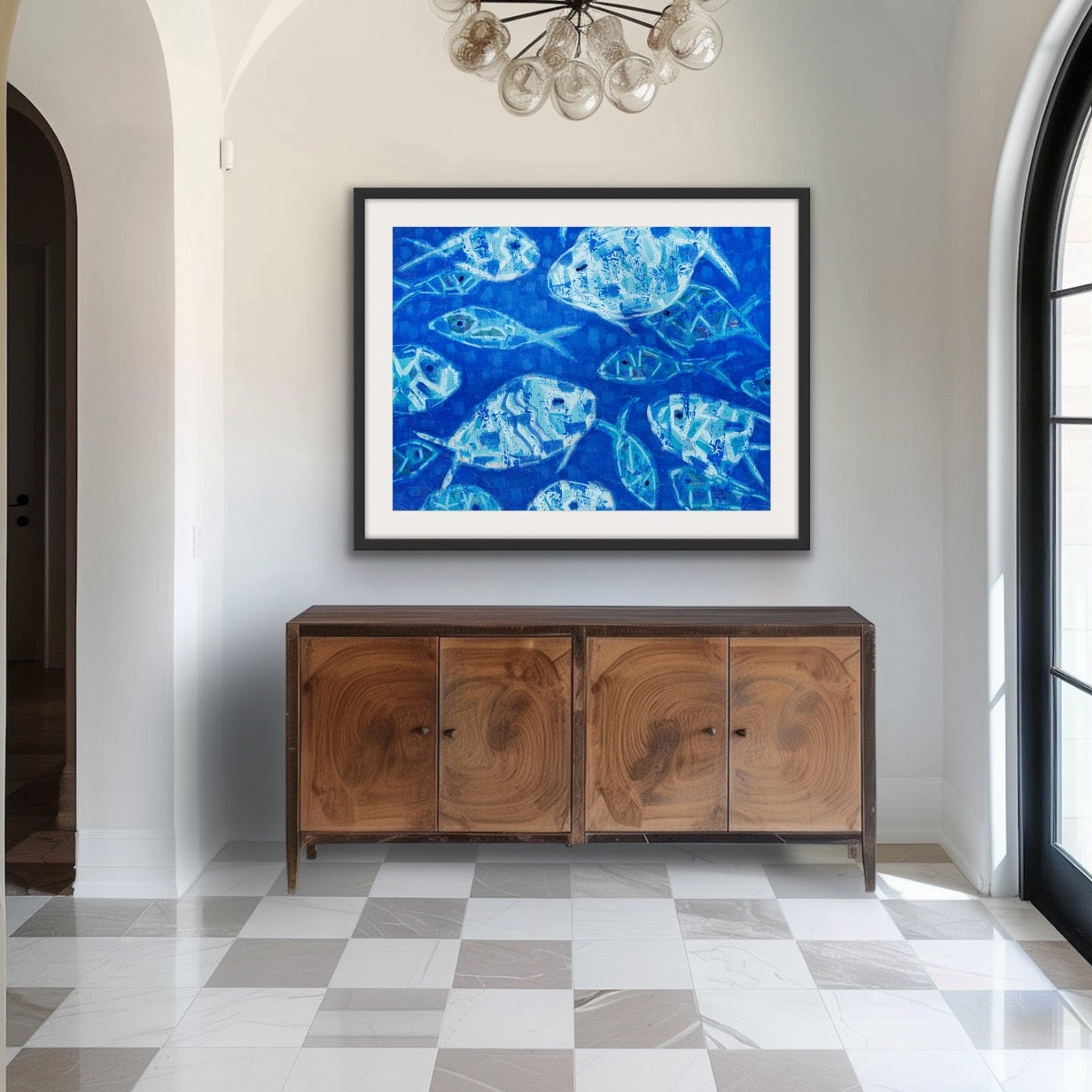 Foyer with wooden sideboard, gallery-style framed blue fish print on cotton rag paper and  a chandelier