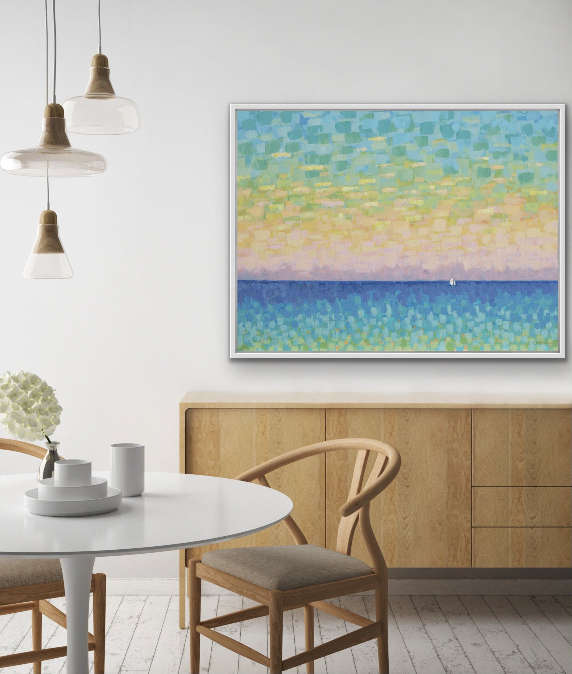 Dining room with a Sunset Sail horizontal canvas print on the wall, white table, and wooden chairs.