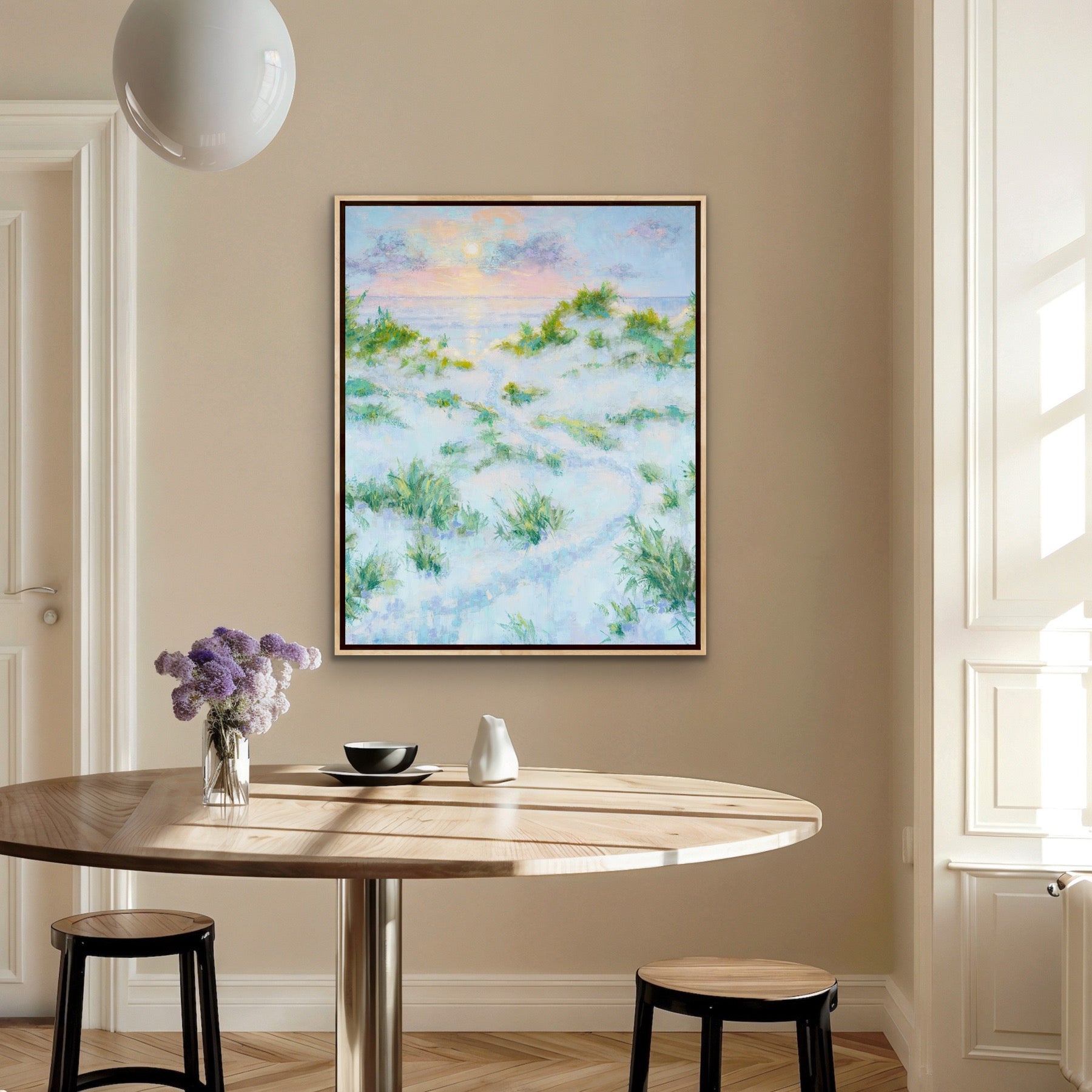 Dining room with a round wooden table, stools, and  Summer Dreams vertical edition framed coastal artwork  on the wall.