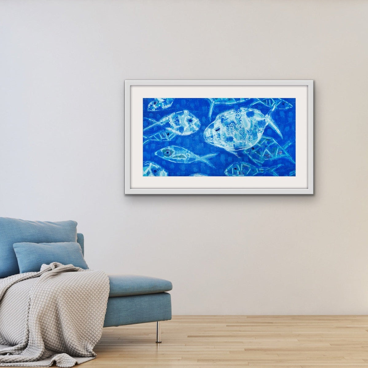 Ocean-inspired fine art print on a wall above a blue armchair in a room with a plant.
