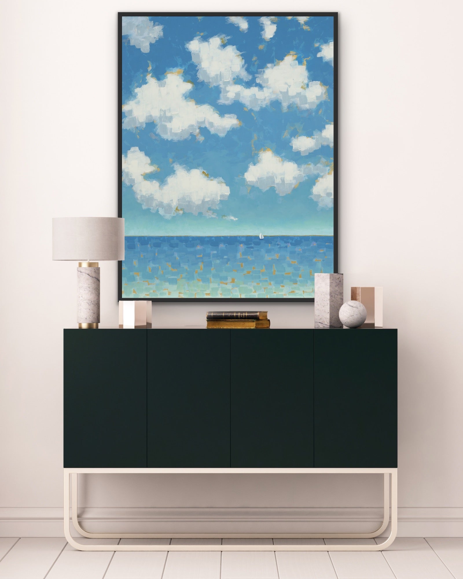 Modern interior with a black cabinet and a blue sky and ocean canvas art with gold-highlighted clouds on the wall.  