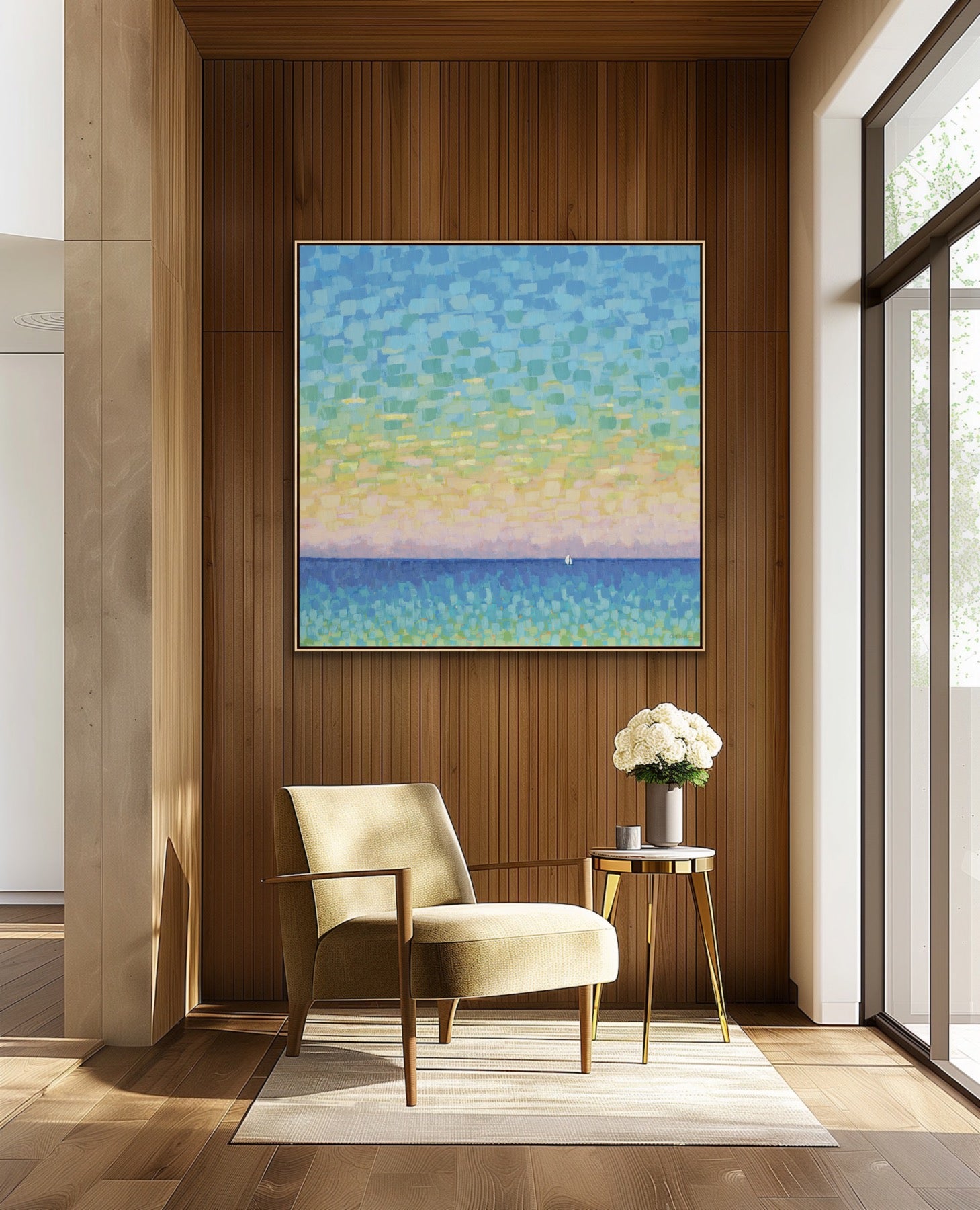 Modern interior with a beige armchair, side table, and an original coastal seascape painting Sunset Sail by Martha Brane featuring expansive sky, sea, and sailboat on a wooden wall.